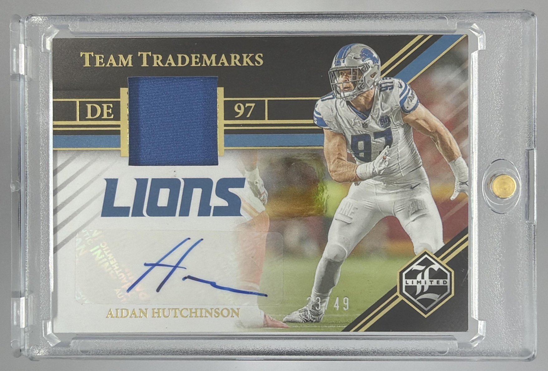 Card image for 2023 Panini Limited Aidan Hutchinson Team Trademarks Signature Materials /49 #TSM-AH MEM Auto Lions