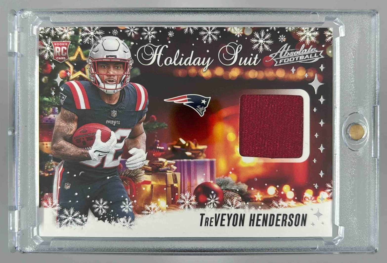 Card image for 2025 Panini Absolute TreVeyon Henderson Holiday Suit MEM RC Patriots
