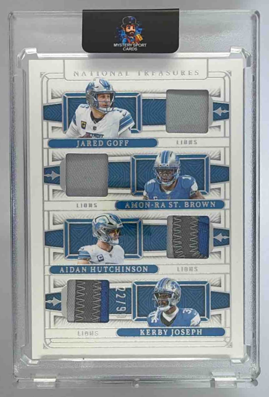 Card image for 2025 Panini National Treasures Jared Goff Aidan Hutchinson Amon-Ra St. Brown Kerby Joseph NFL Gear Quad Materials /99 #NQM-DET MEM Lions